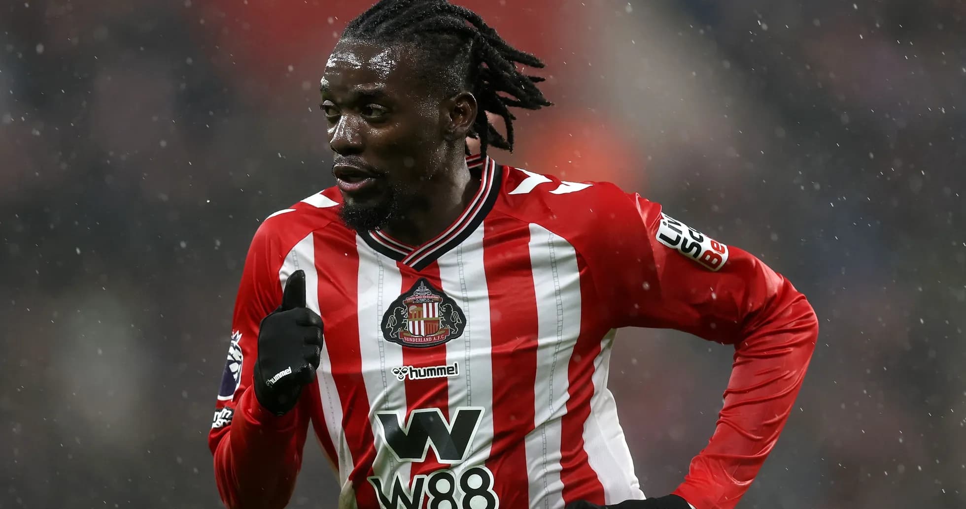 Player in Sunderland kit running on snowy pitch