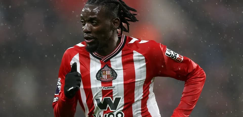 Player in Sunderland kit running on snowy pitch