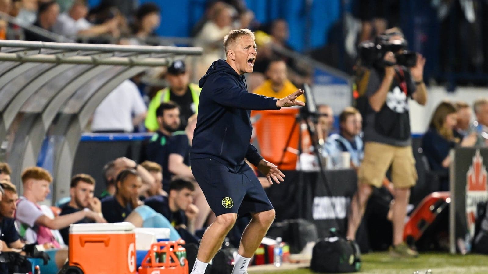 Coach directing players from the sideline during match
