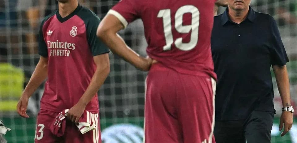 Two players and coach on field after match