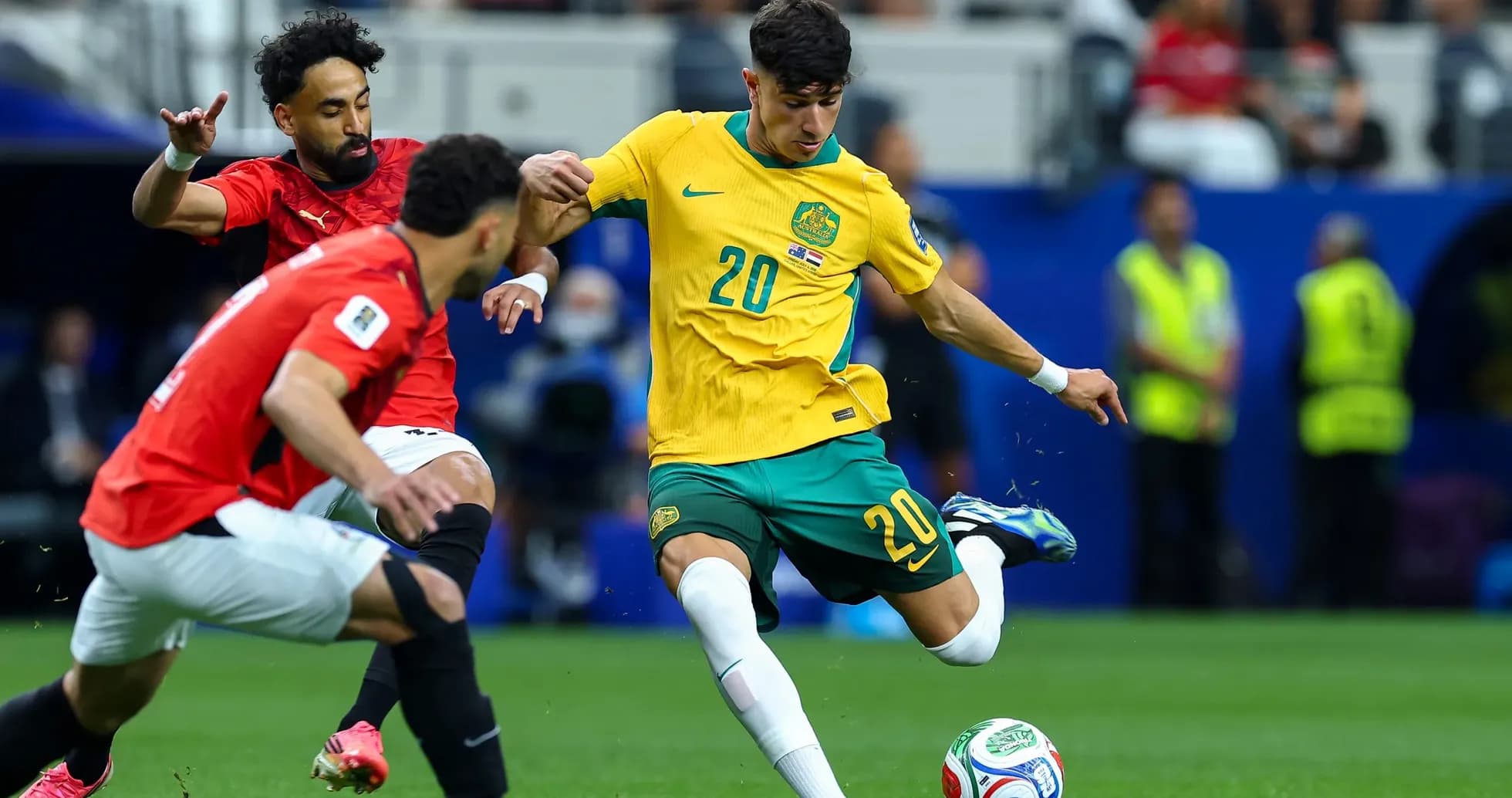 Australian player dribbling past Egyptian defenders