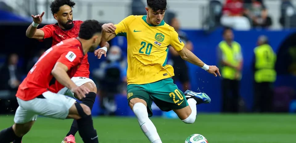 Australian player dribbling past Egyptian defenders