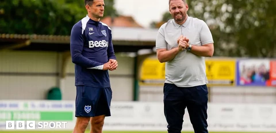Two coaches discussing strategy on training pitch
