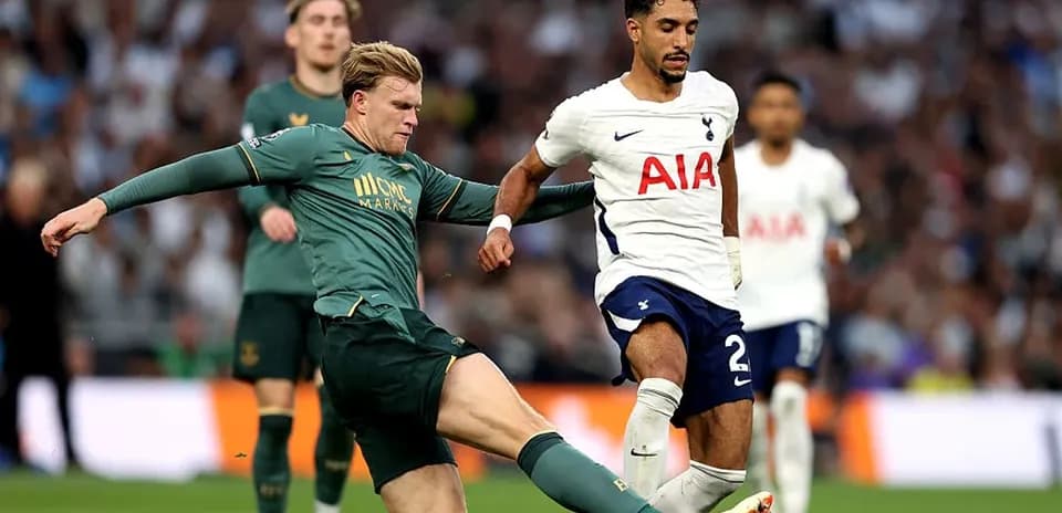 Player from Tottenham challenged by opponent during match