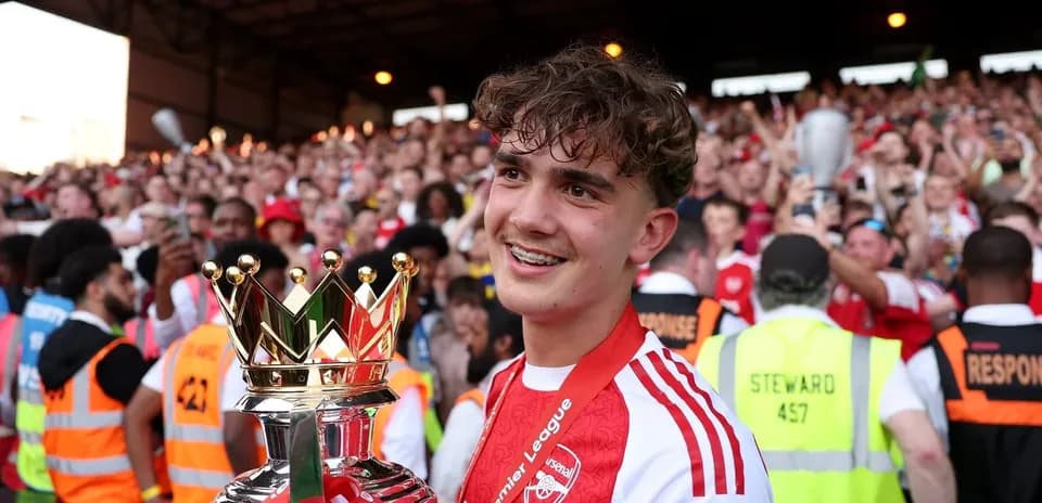 Player celebrating with Premier League trophy and fans