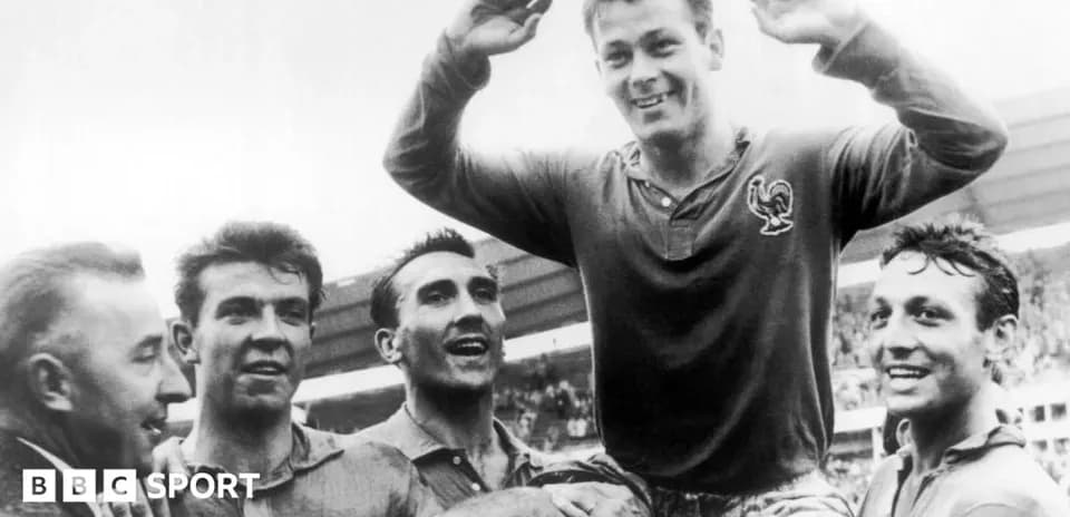 Players celebrating a victory, one lifted in triumph