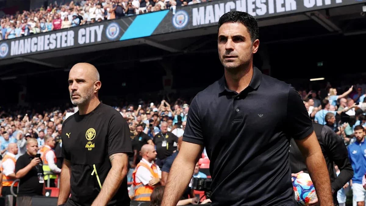 Two coaches walking onto the pitch at stadium