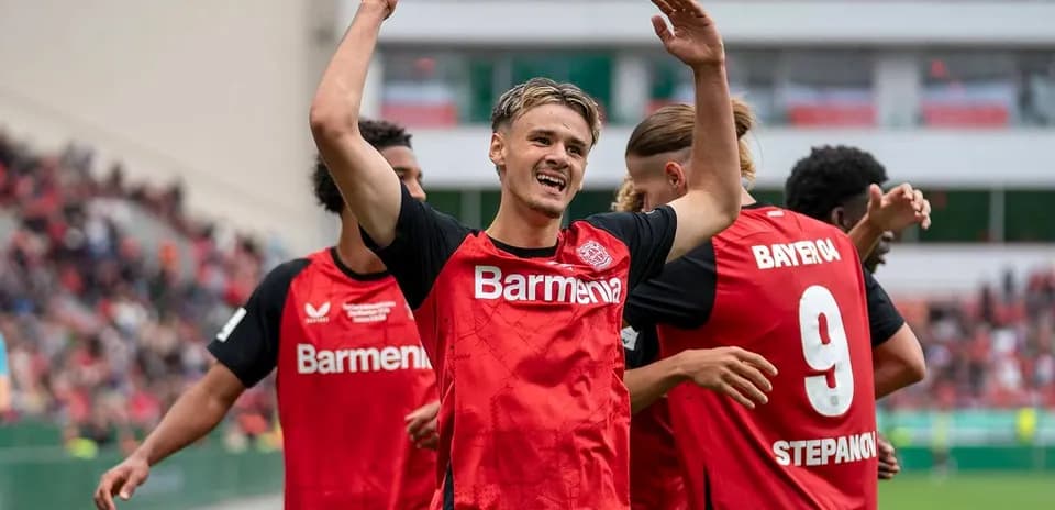 Player celebrating with teammates after scoring goal