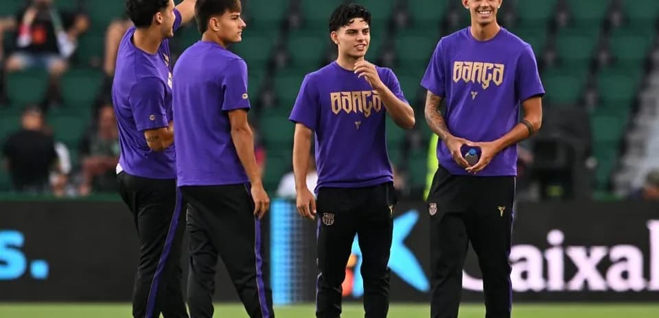 Four players warming up in purple jerseys on field