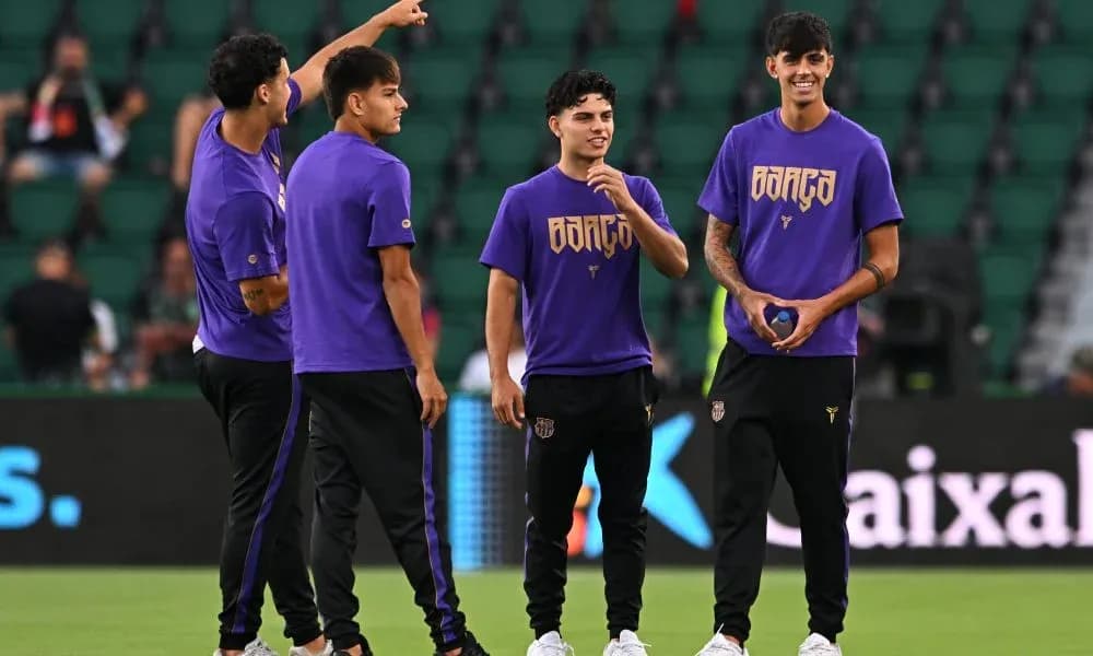 Four players warming up in purple jerseys on field