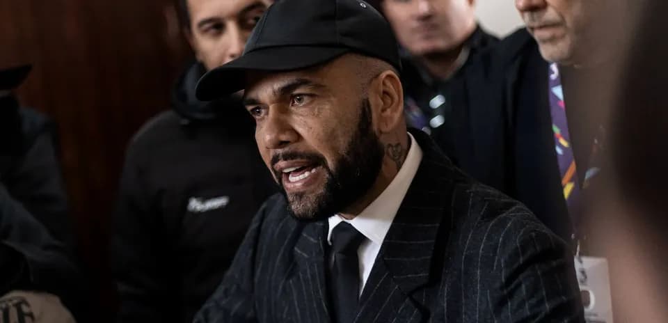 Man speaking during a press conference surrounded by others