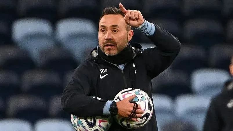 Coach gesturing while holding soccer balls during training