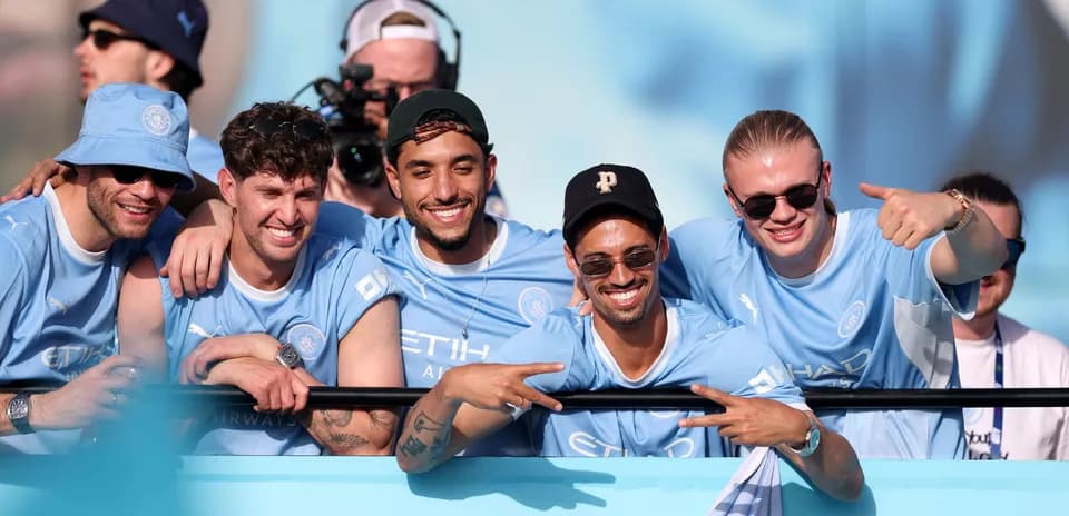 Fans celebrating together in Manchester City jerseys
