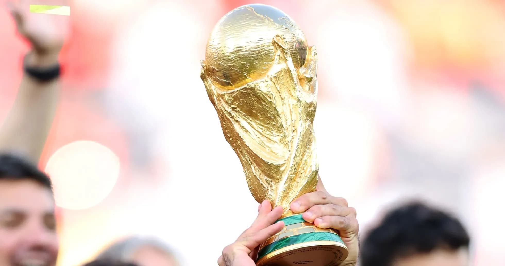 Golden FIFA World Cup trophy being held aloft