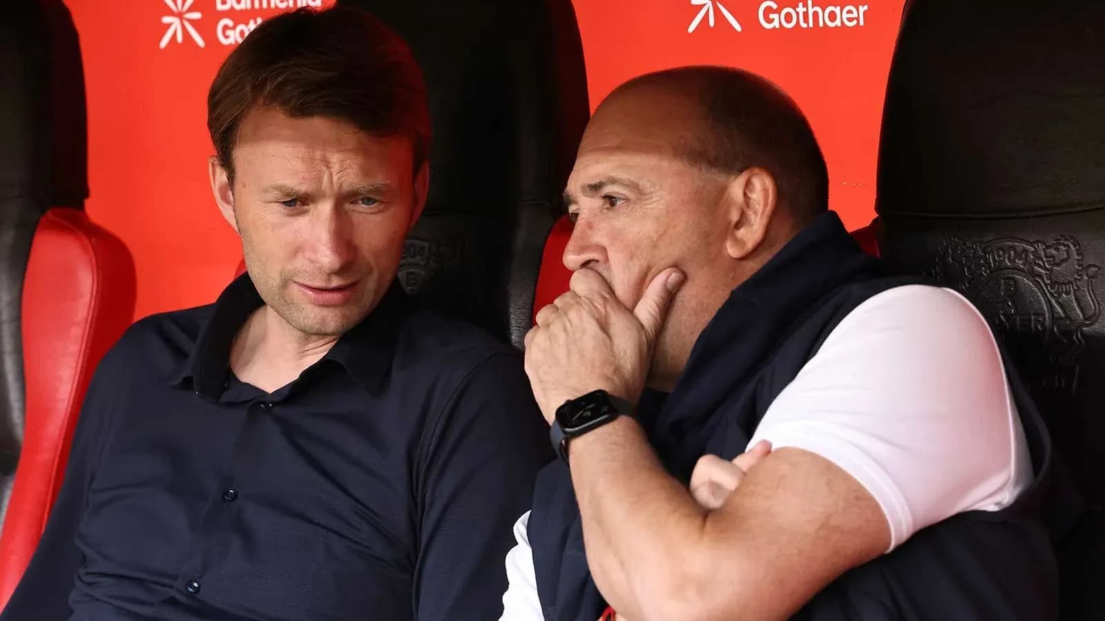 Coaches discussing strategy on the bench