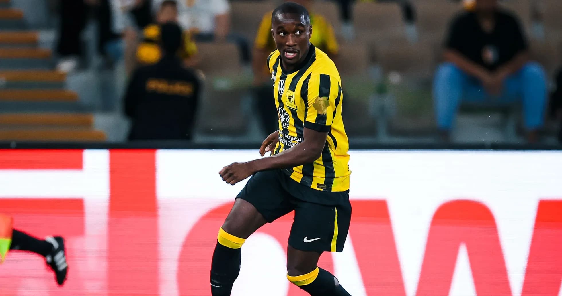 Player in yellow and black kit dribbling the ball