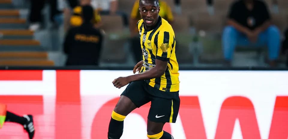 Player in yellow and black kit dribbling the ball