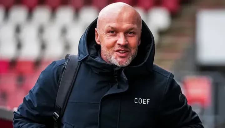 Man in coat arriving at stadium entrance