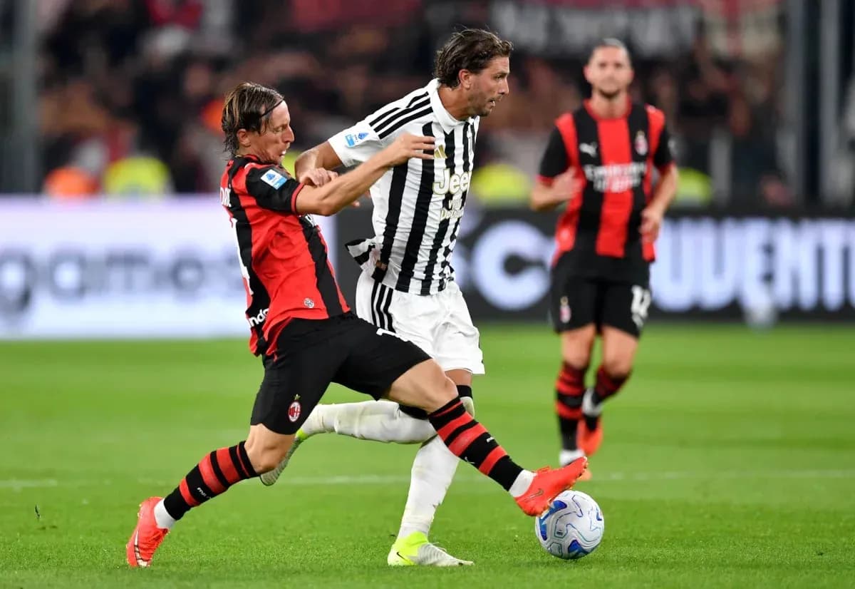 Player from AC Milan tackling Juventus player during match