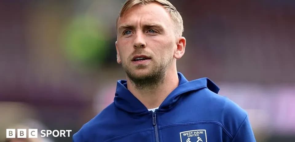 Player wearing West Ham United hoodie on pitch