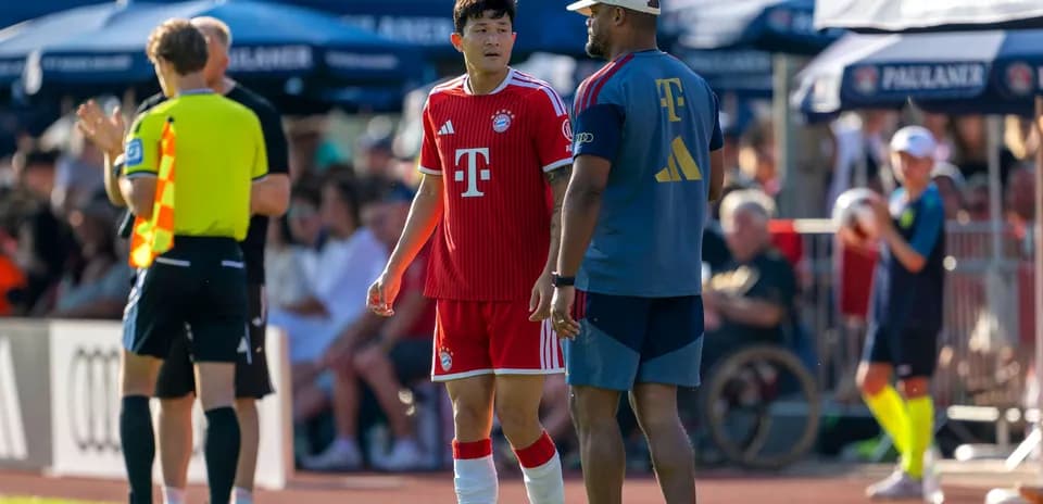 Bayern Munich player talking to coach during match