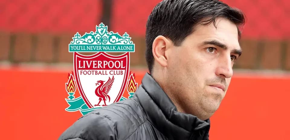 Coach standing near Liverpool FC logo