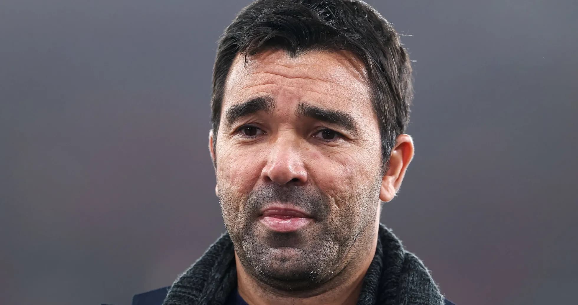 Man with short dark hair and beard speaking