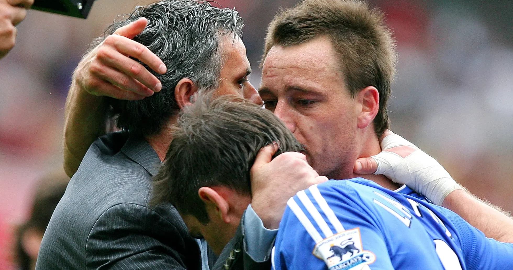 Players and manager embracing on the pitch