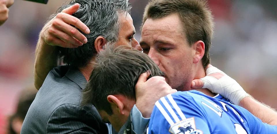 Players and manager embracing on the pitch