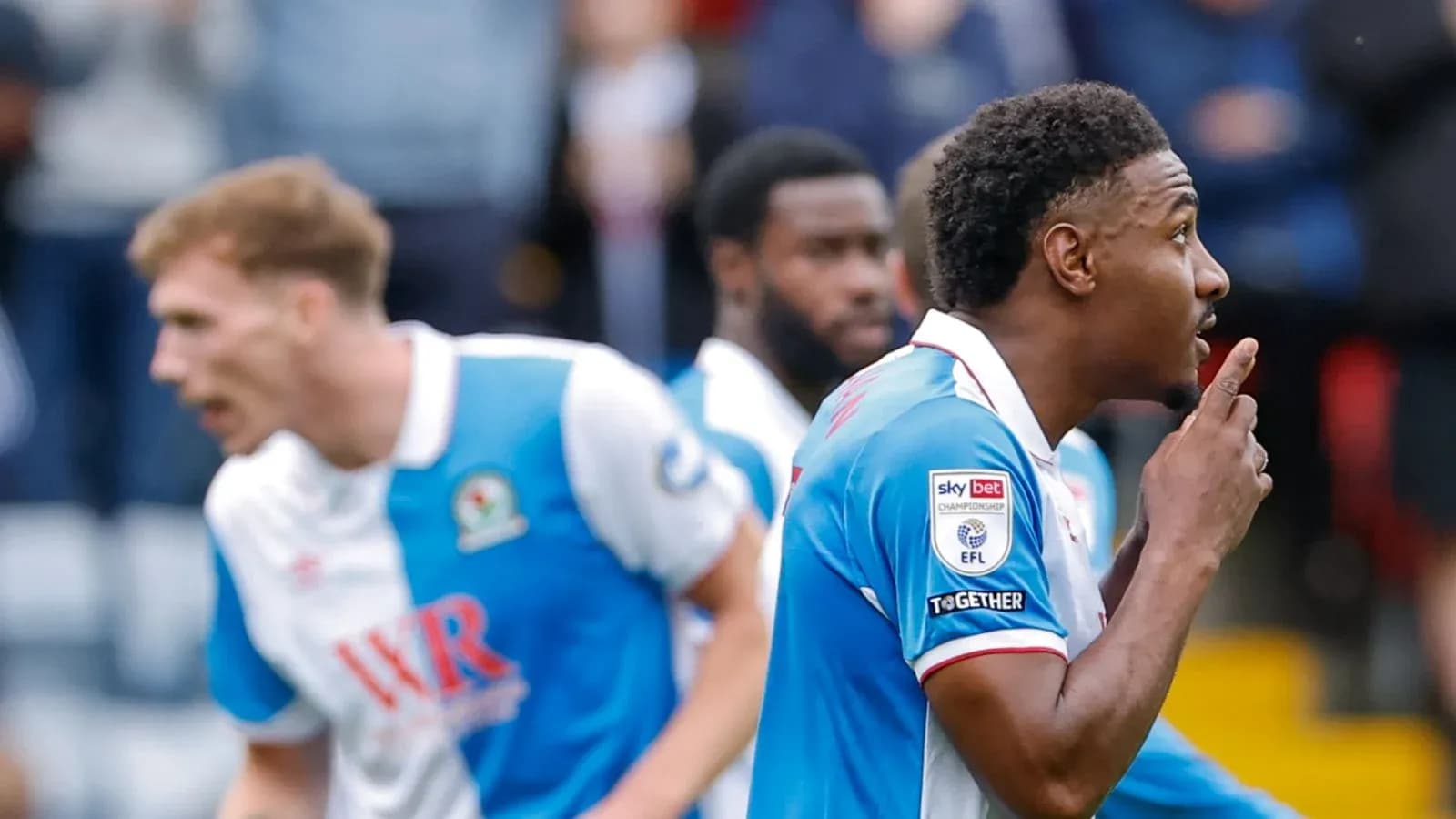 Blackburn Rovers players celebrating a goal on pitch Blackburn Rovers players celebrating a goal on pitch