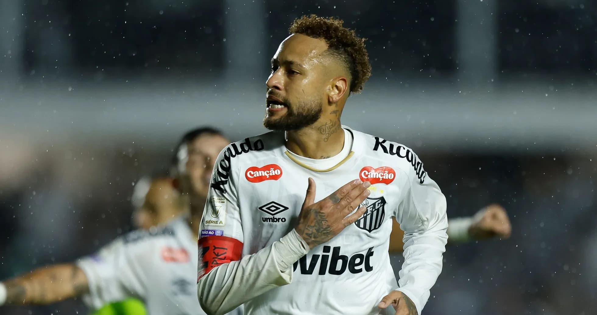 Player celebrating a goal during a rainy match Player celebrating a goal during a rainy match