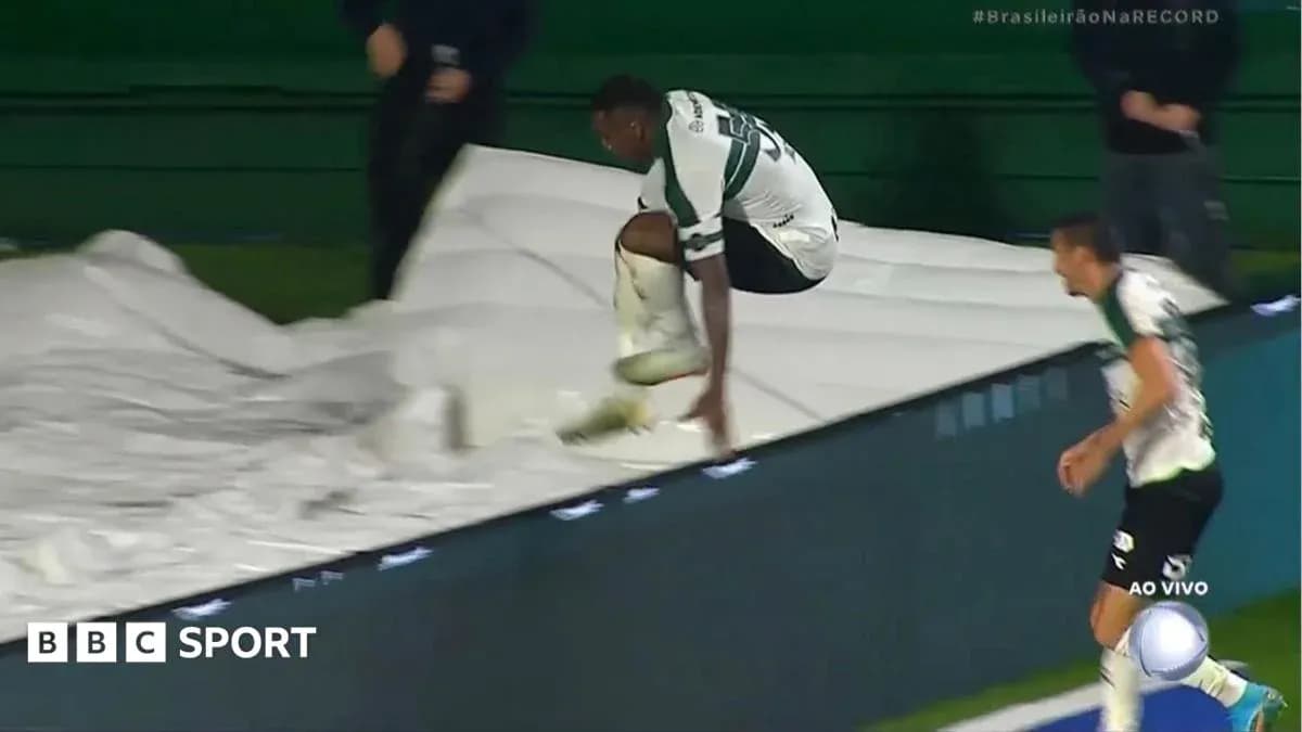 Player jumping over protective tarpaulin during match Player jumping over protective tarpaulin during match