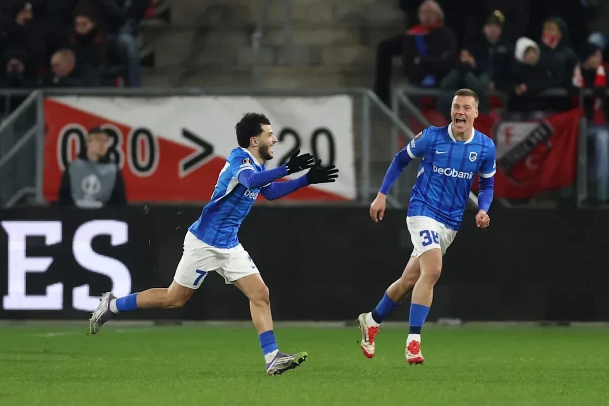 Two players celebrating a goal in blue uniforms Two players celebrating a goal in blue uniforms