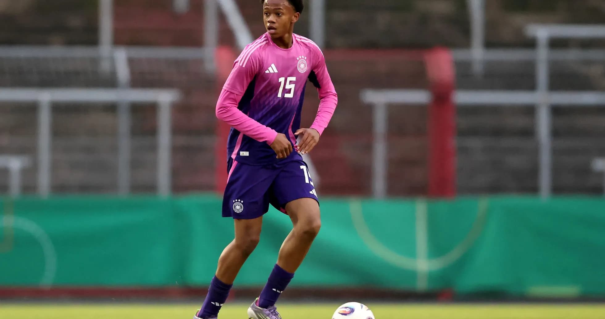 Player in pink and blue uniform dribbling soccer ball Player in pink and blue uniform dribbling soccer ball