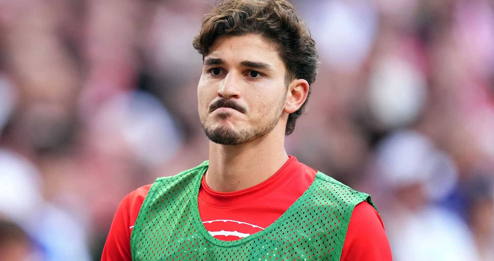 Player in training gear on sidelines during match Player in training gear on sidelines during match
