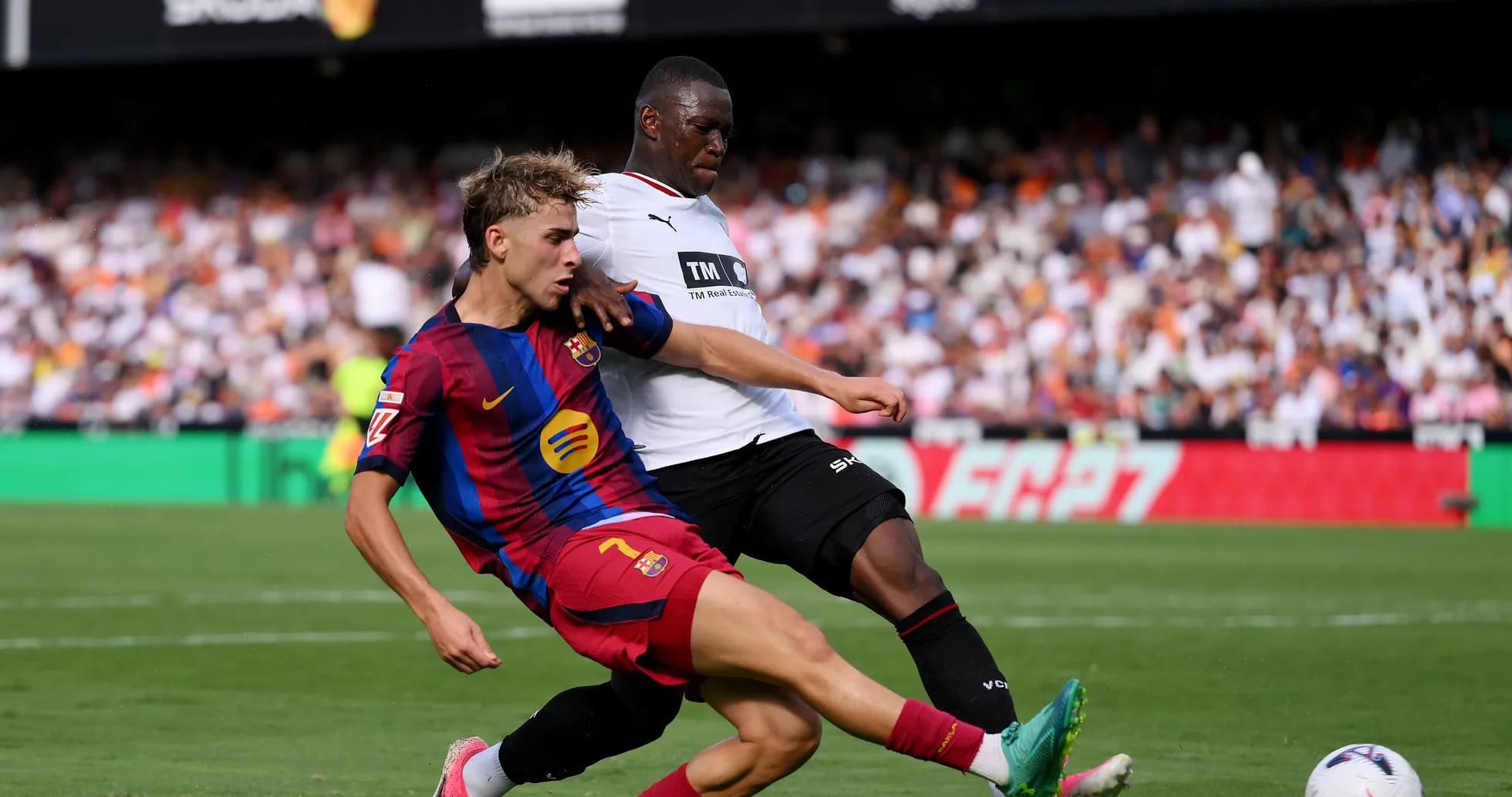 Barcelona player challenged by opponent during match Barcelona player challenged by opponent during match