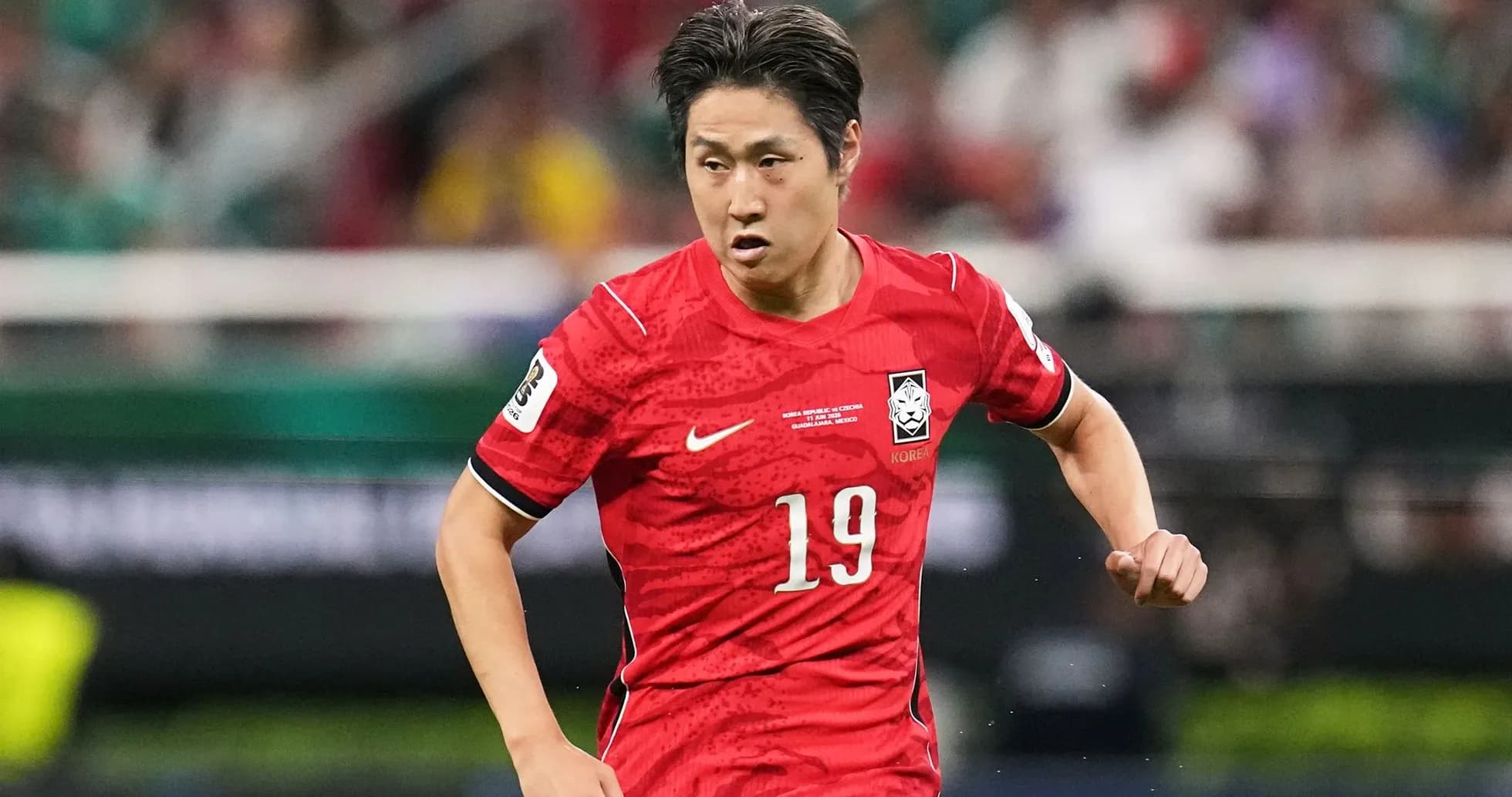 Player in red jersey running during a match Player in red jersey running during a match