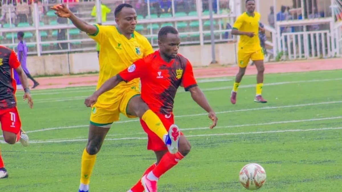 Kano Pillars player dribbling past Doma United opponent Kano Pillars player dribbling past Doma United opponent