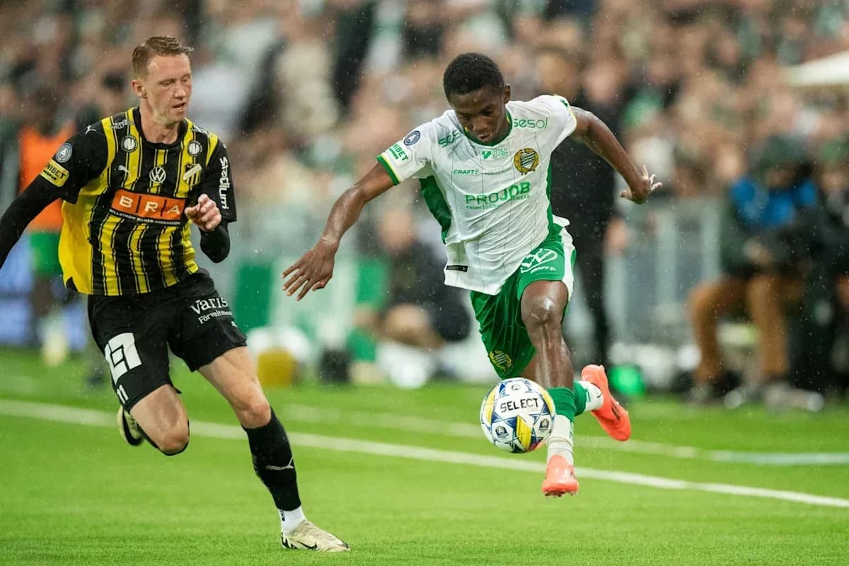Player in green dribbling past opponent in black jersey Player in green dribbling past opponent in black jersey