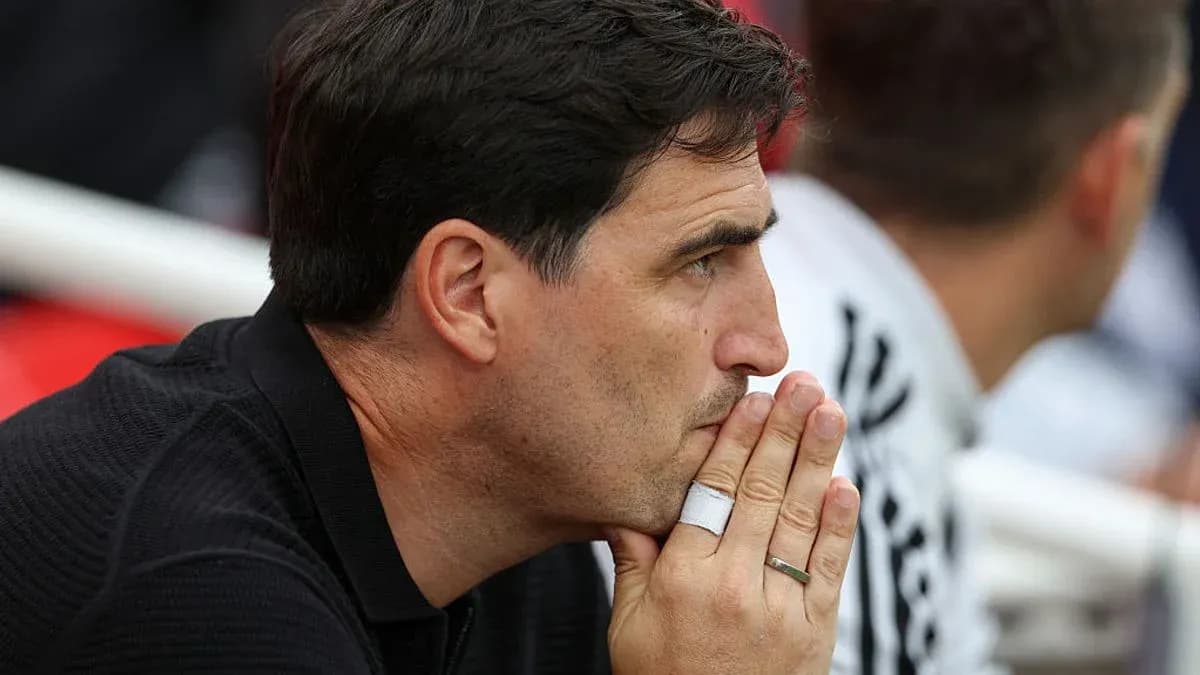 Coach watching match with hands clasped in thought Coach watching match with hands clasped in thought