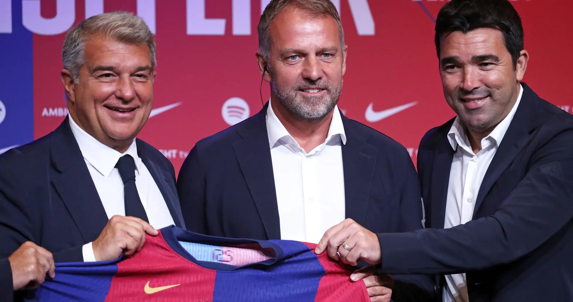 Three officials presenting a Barcelona jersey at event Three officials presenting a Barcelona jersey at event
