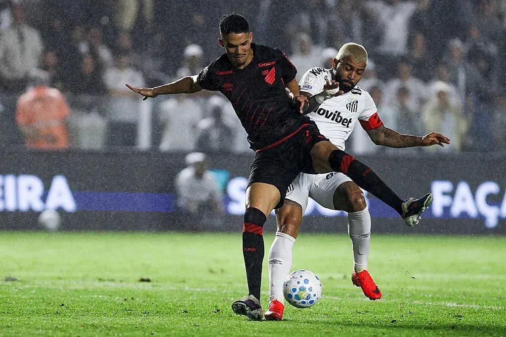 Two players contesting the ball in a rainy match Two players contesting the ball in a rainy match
