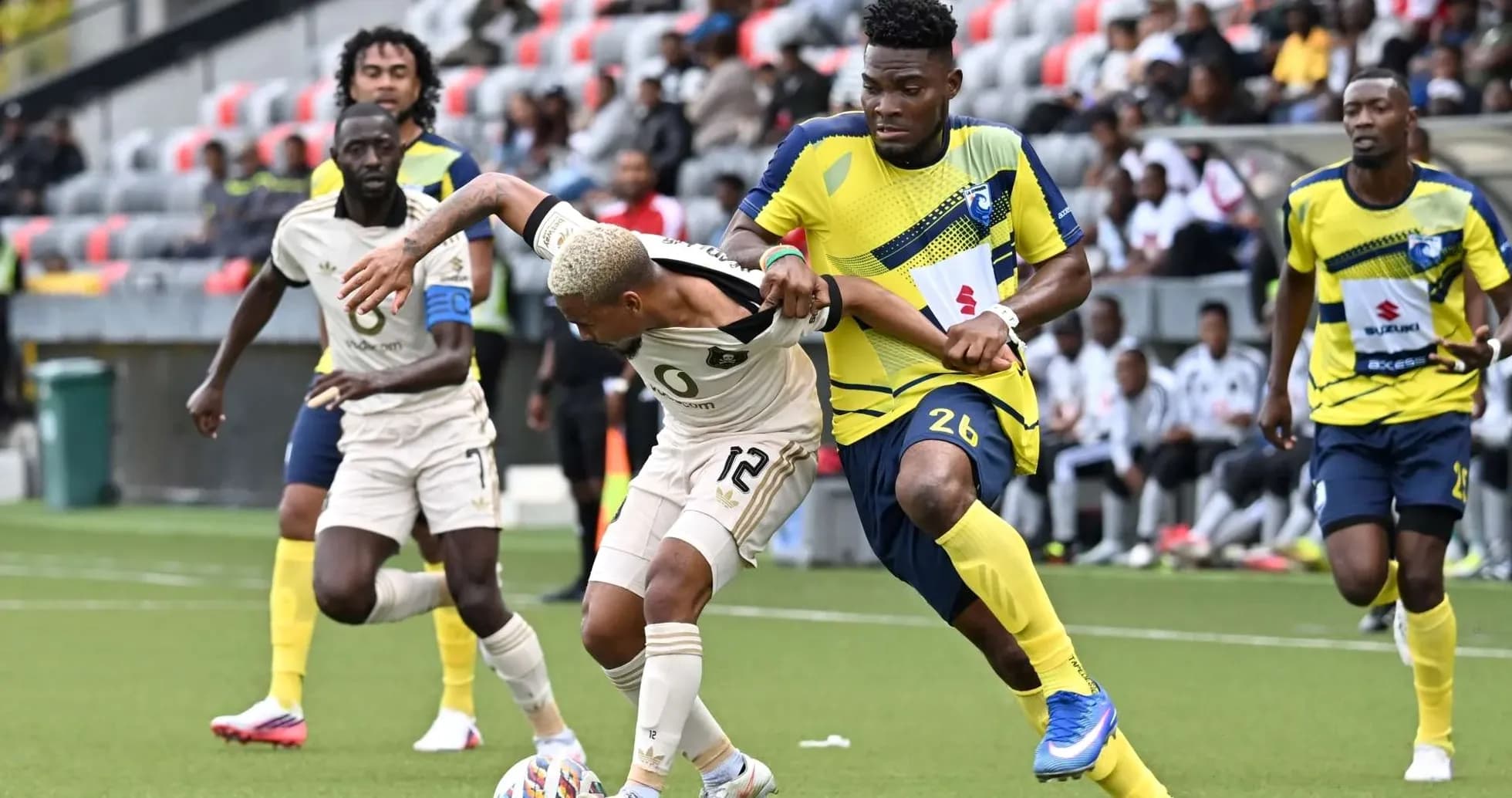 Orlando Pirates player challenged by La Cure Waves opponent Orlando Pirates player challenged by La Cure Waves opponent