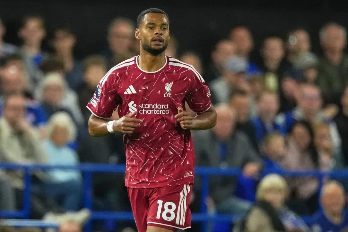 Liverpool player running during match with fans in background Liverpool player running during match with fans in background