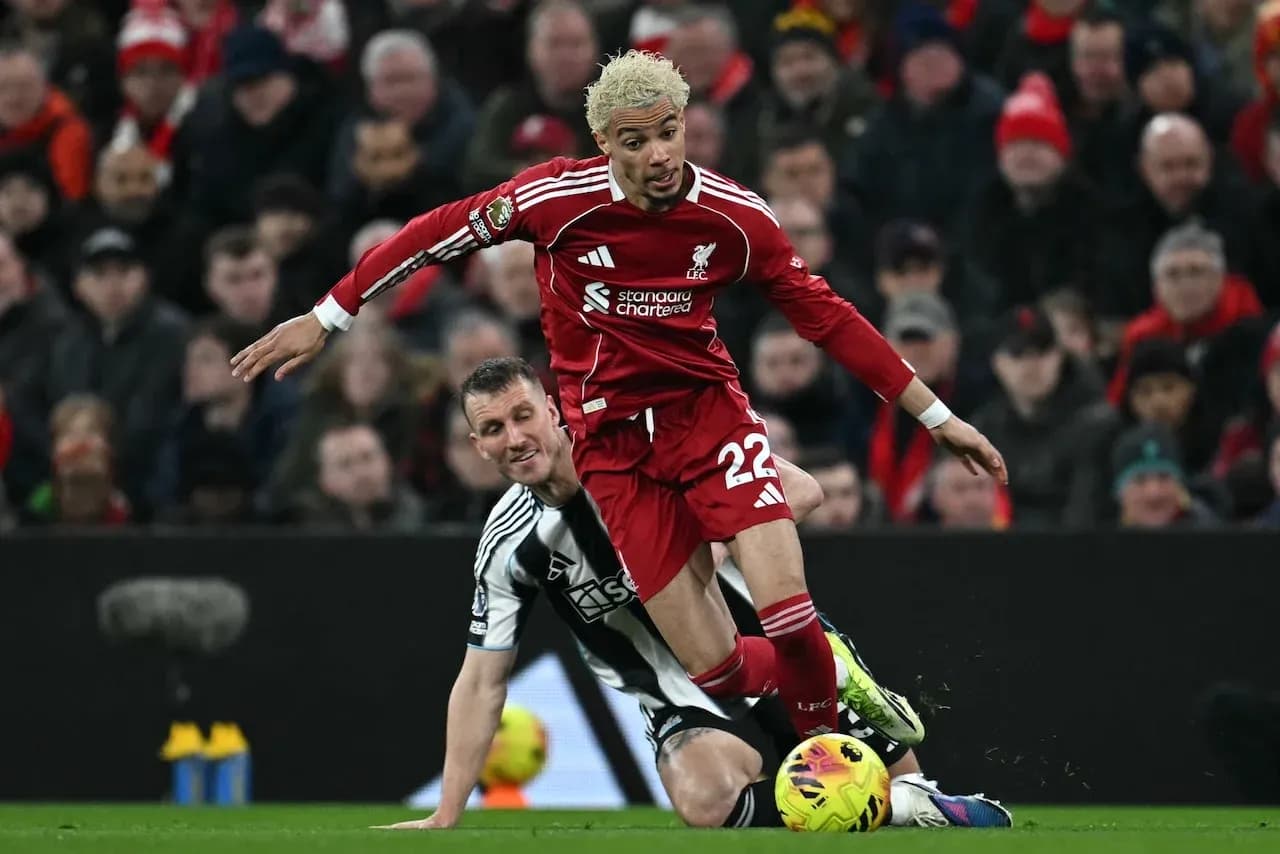Liverpool player challenging Newcastle opponent during match Liverpool player challenging Newcastle opponent during match
