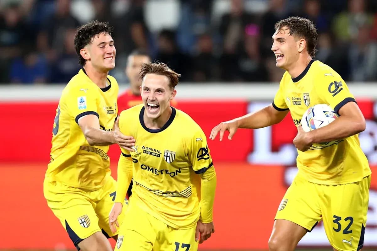 Three players celebrating a goal in yellow jerseys Three players celebrating a goal in yellow jerseys