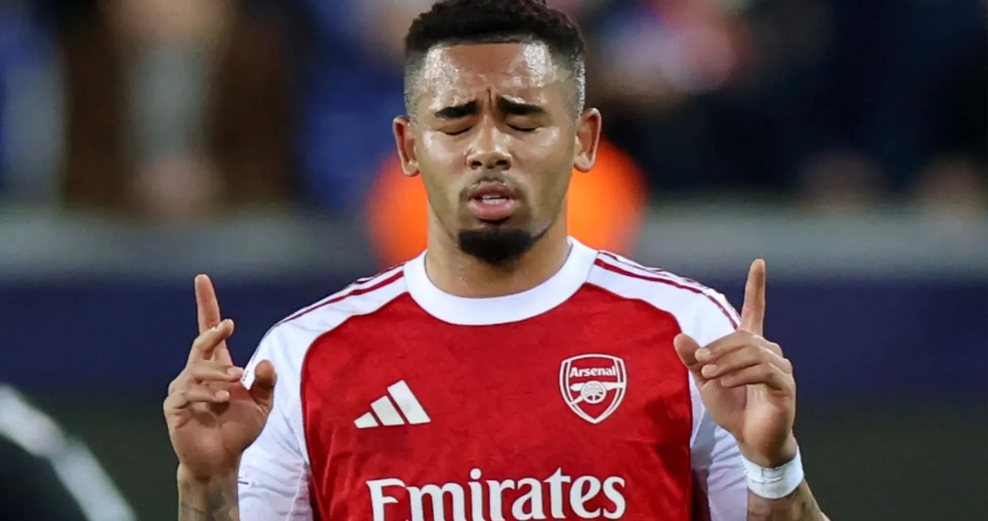 Player praying during a match wearing Arsenal jersey Player praying during a match wearing Arsenal jersey
