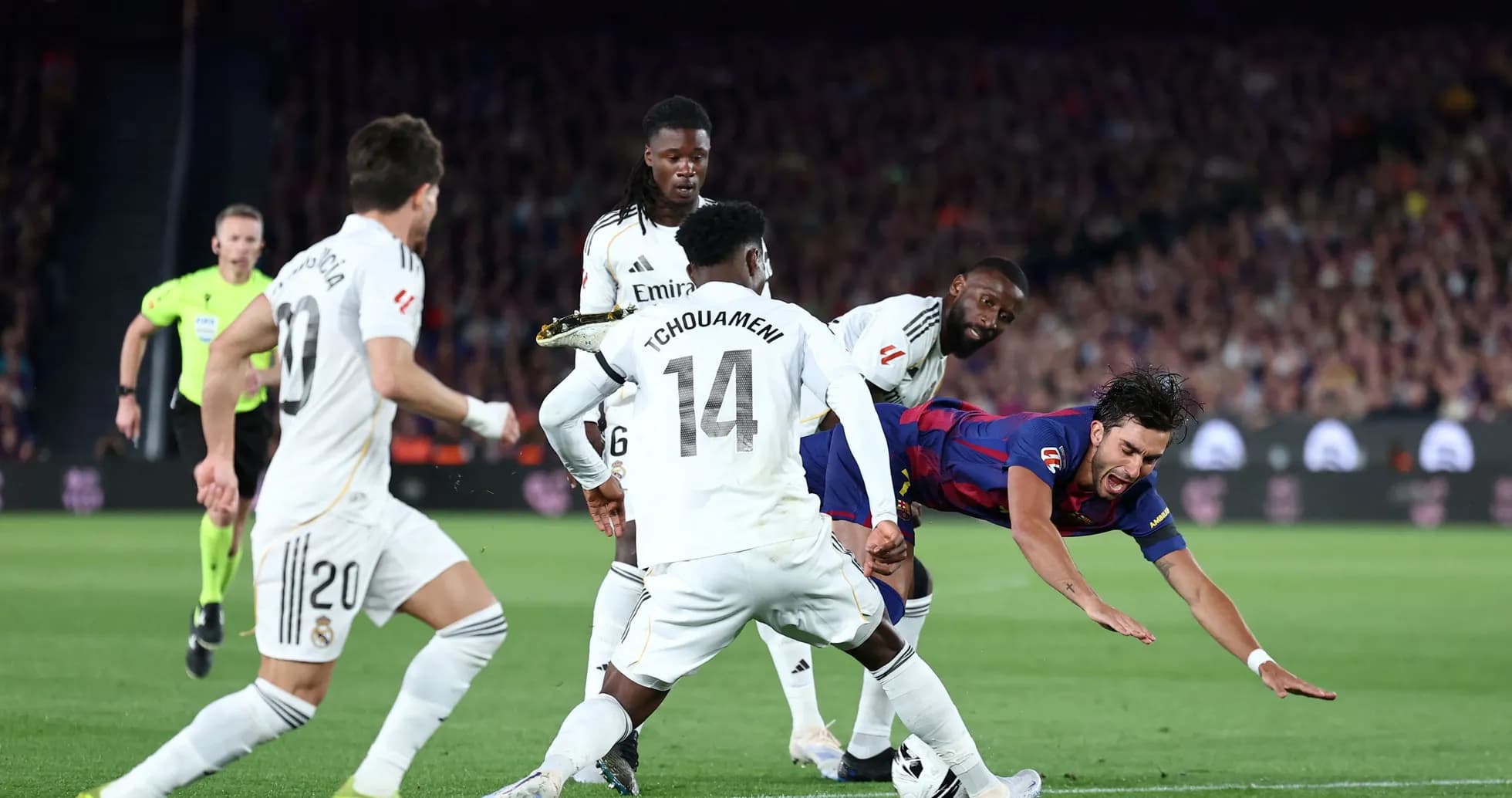 Barcelona player falling while surrounded by Real Madrid defenders Barcelona player falling while surrounded by Real Madrid defenders