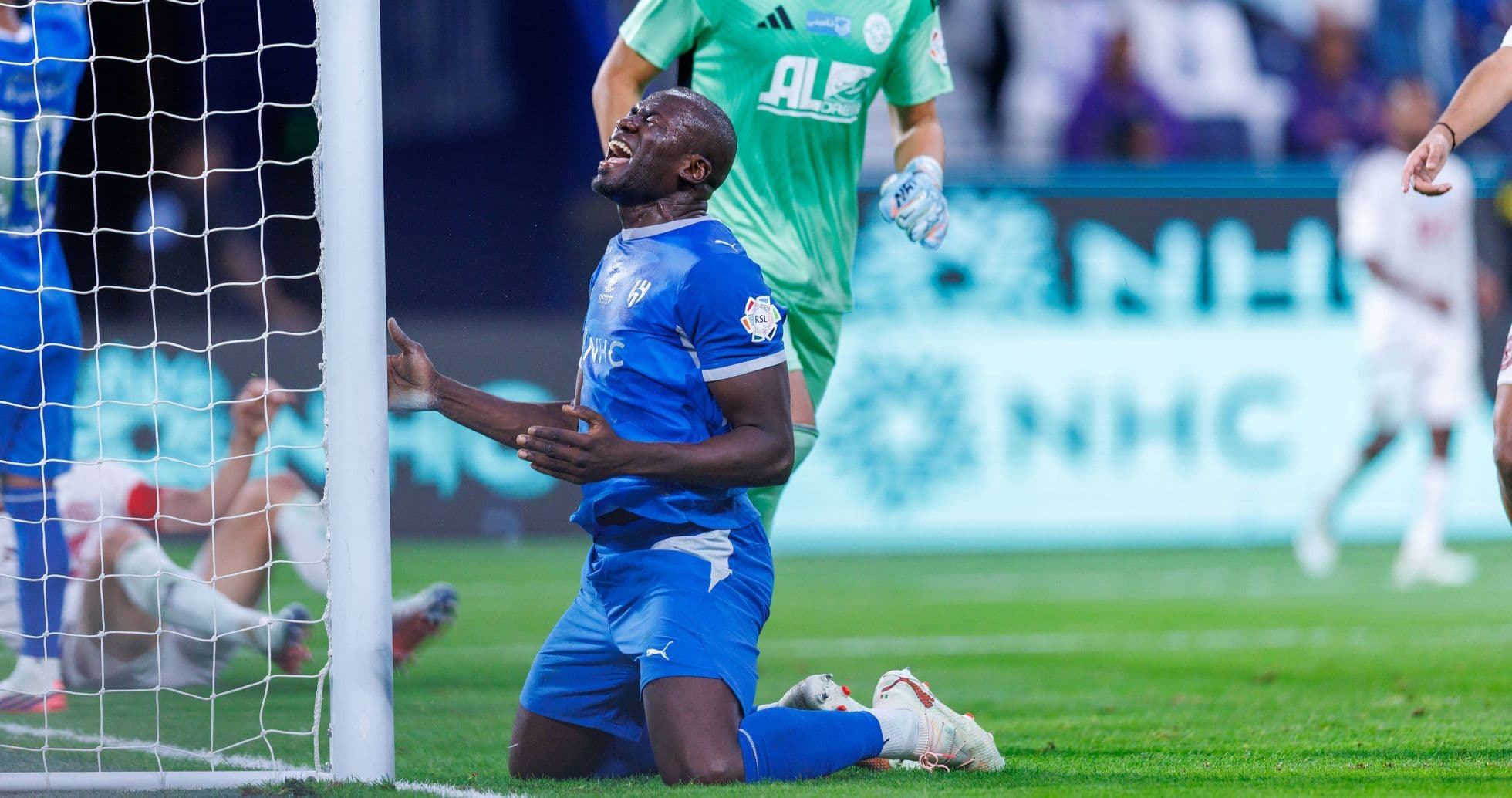 Player kneeling near goalpost after missed opportunity Player kneeling near goalpost after missed opportunity