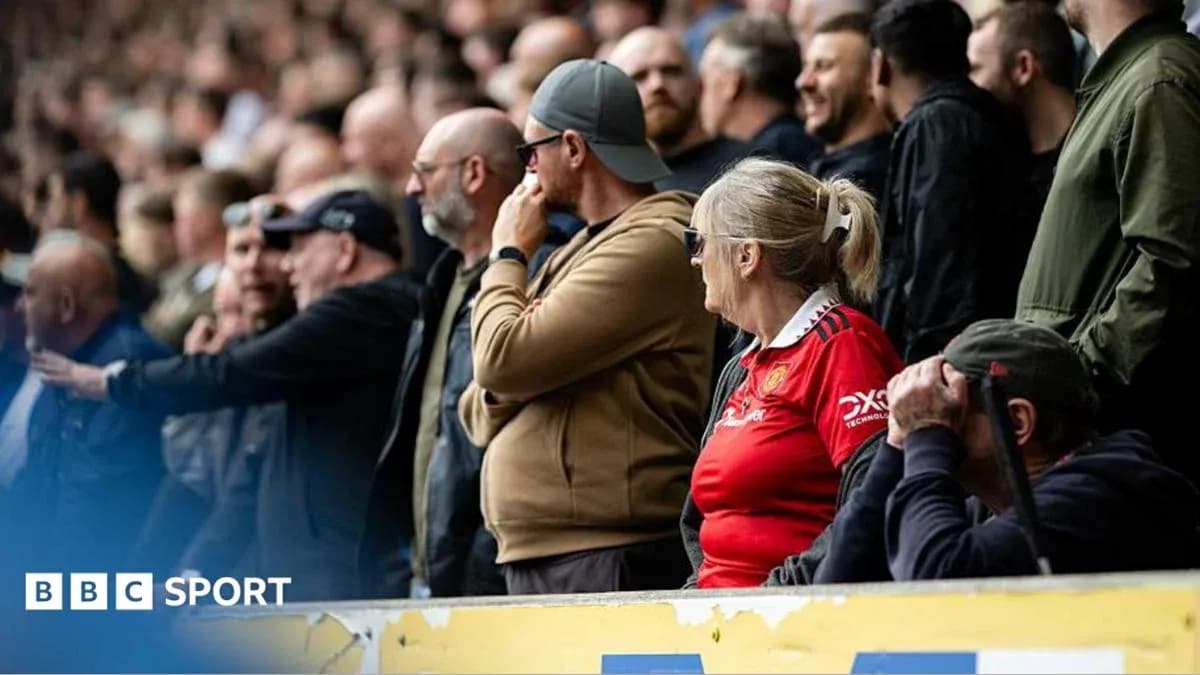 Fans watching a match in the stadium stands Fans watching a match in the stadium stands